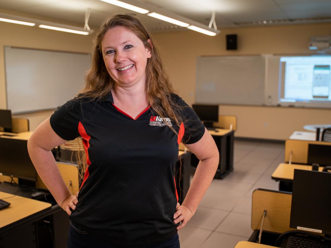 Jennifer Bailey stands smiling in a classroom.