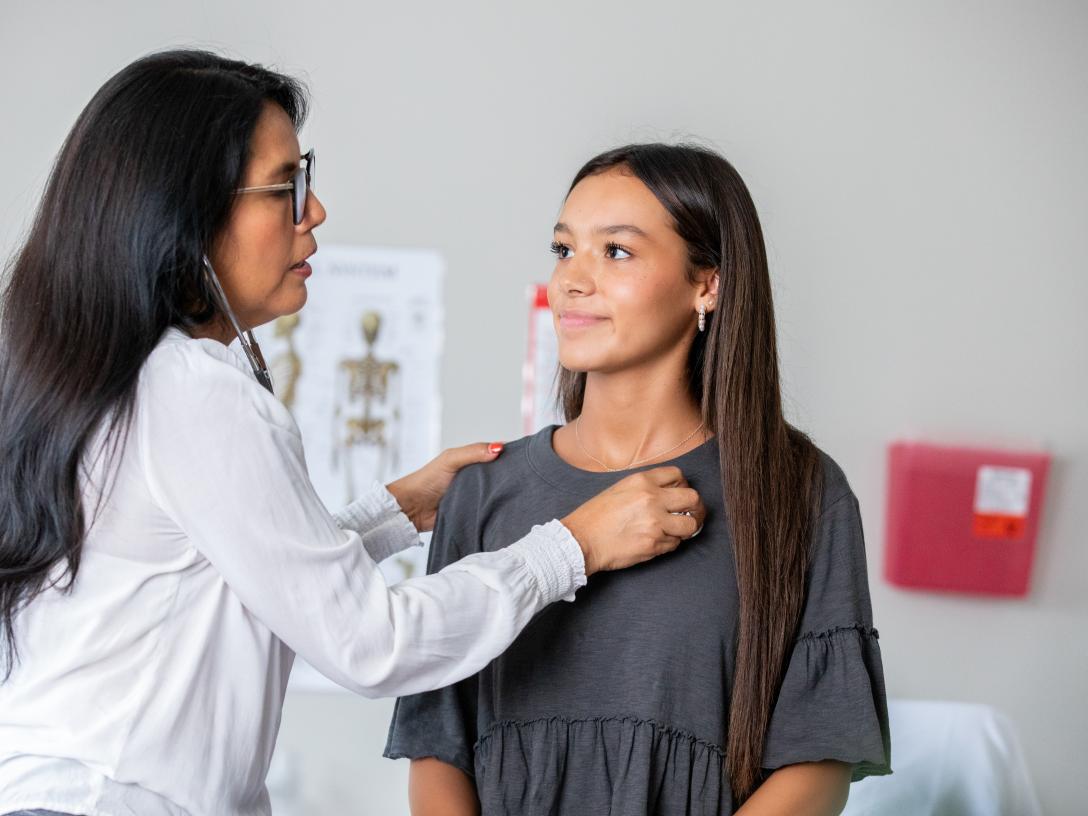 Doctor with listening to a student's heartbeat