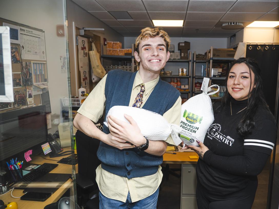Two students holding frozen turkeies