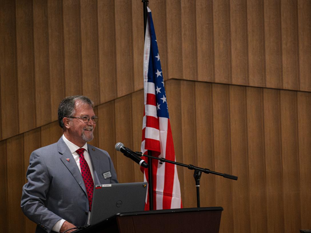 Johnny Sowder speaks at a podium with a USA flag to his left