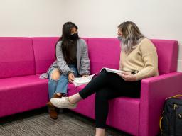 Aims students in the lounge wearing face masks, discussing books