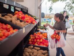 Farms to Families Food Truck with student choosing veggies