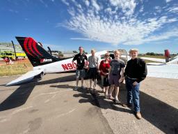 Group standing by airplane at Aviation Day