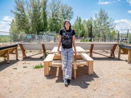 Keira Zabel and the picnic table she created at Loveland Youth Gardeners youth-led farm.