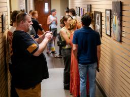 People looking at pictures and paintings at Aims art show