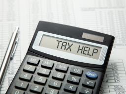 Calculator that says Tax Help with pen and spreadsheets