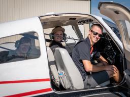 People smiling from Aims plane at Aviation Day