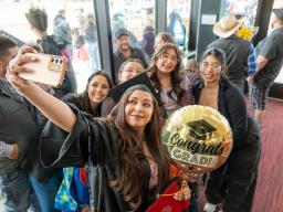 Selfie of Graduate with balloon and family and friends