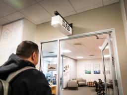 A student walking into the door of the Aims Disability Access Services Office