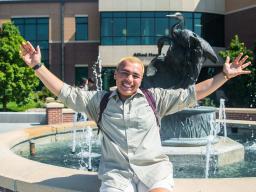 Student at in front of a fountain on Greeley Campus