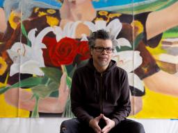 Frank Garza in front of his art