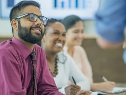 Professionals in a classroom listing to a presenter