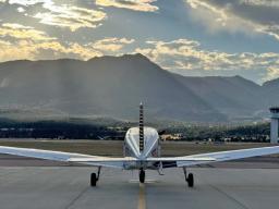 Airplane in front of mountain at sunset