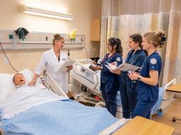 Nursing students and instructor in mock hosptial room