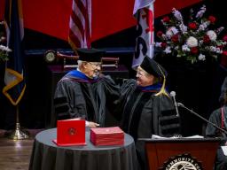  Lyle Achziger and  Marilyn Schock, Chair of the Aims Board of Trustees on the Commencement Stage