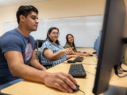 3 students on computers in Aims computer lab