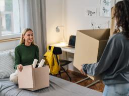 Students with boxes moving in to bedroom
