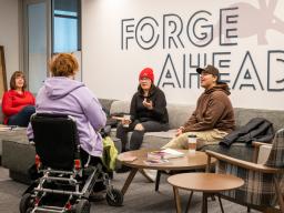 Students at the Student Commons Lobby with Forge Ahead art on the wall