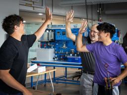 teacher and two students high fiving each other