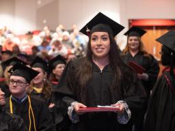 Graduating student and other graduatutes during commencement at Aims