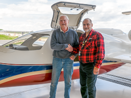 Two men standing by an airplane
