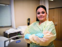 Aims CNA student in hosptial room with rubber gloves