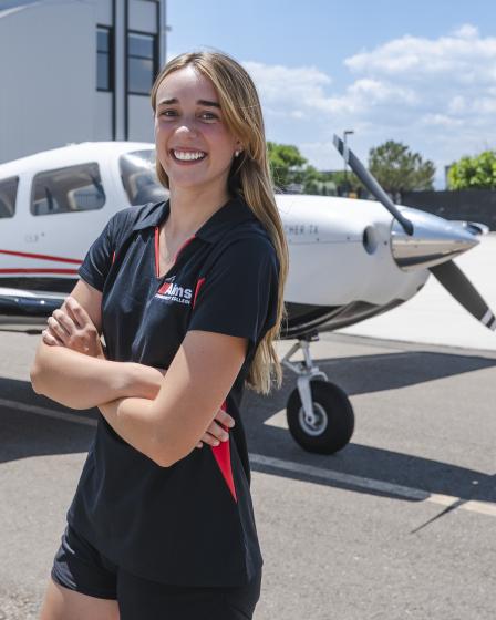 Samantha Walsh with plane and Aims Flight Training Center in the background
