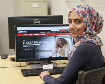 student in front of a computer in a computer lab