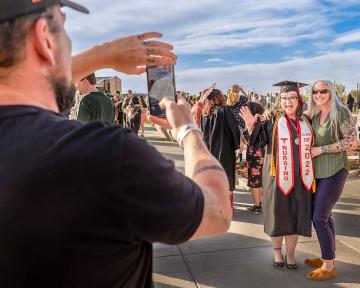 Nursing program graduate and President’s Medallion recipient Jessica Riley poses for a celebratory photo at the Aims 2022 Spring Commencement ceremony