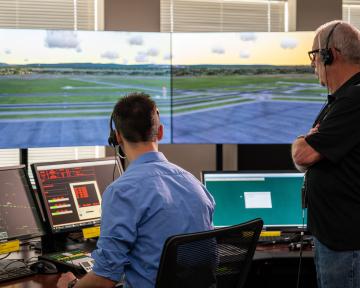An Aims air traffic controller program instructor with student in a control tower