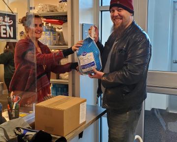 Student recieving a turkey from Arty's Pantry window