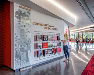 A person looking at the Aims Welcome Center story wall. 