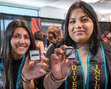 Students holding pins from CDI Graduation Celebration