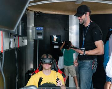 child in flight simulator as an adult watches