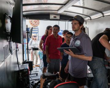 people in mobile aviation lab looking at equipment