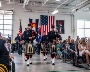 bagpipe players in a line with flags at Fire Academy Graduation