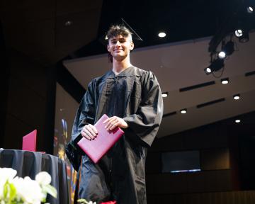 student with diploma on stage