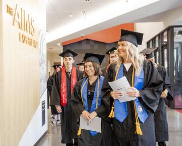 students entering in caps and gowns