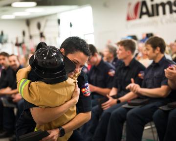 child hugging parent at fire academy graduation