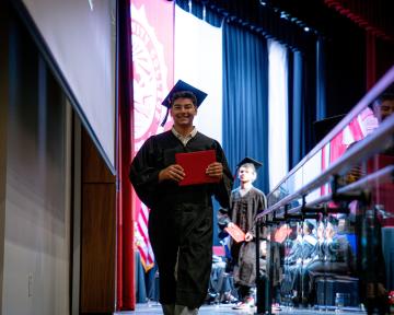 student walking off graduation stage