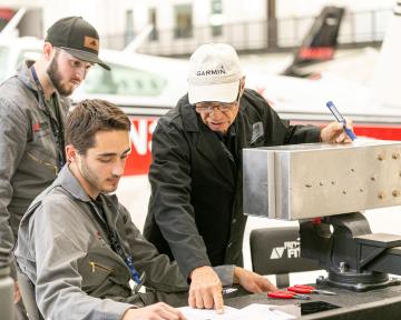 Aviation Maintenance Technician student and instructor examine equipment