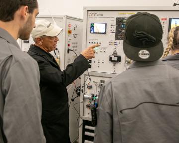 Aviation Maintenance Technician students and professor look at training equipment