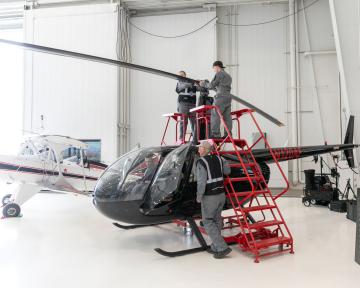Aviation Maintenance Technician students work on a helicopter 