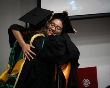 graduates hug