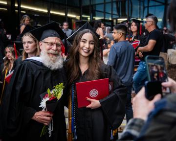 Student with professor posing for graduation photo