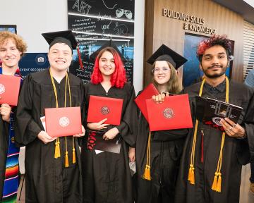 Aims Community College graduates pose for a photo inside the Welcome Center on the Greeley Campus