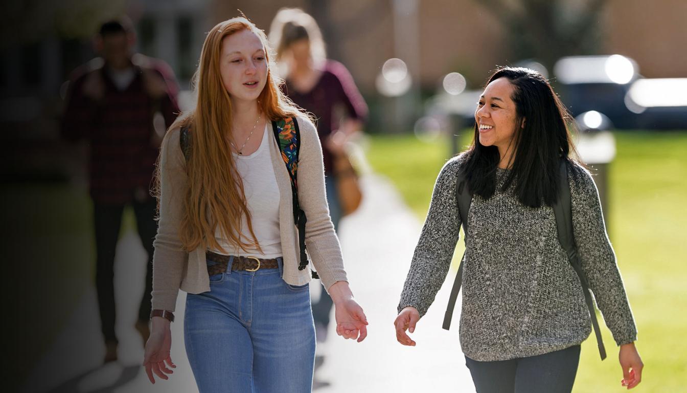 Two transfer students talking and walking on campus