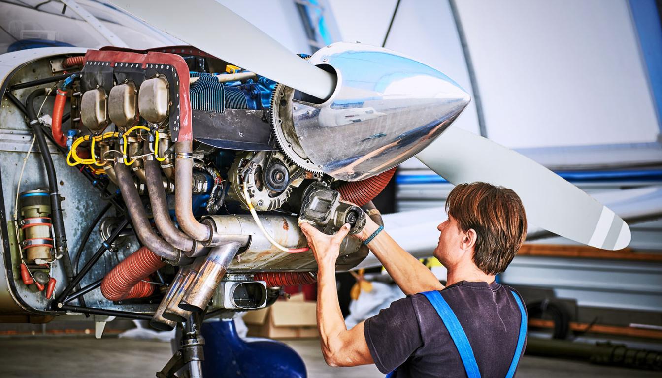 Man working on airplane propeller motor