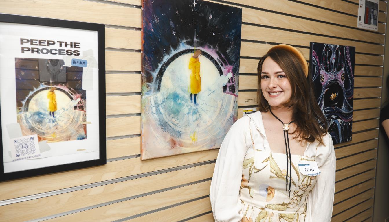 Hannah Janssen stands next to her mixed media piece, And the Moon Said Reflect, which won Best in Show at the Aims Student Art Show