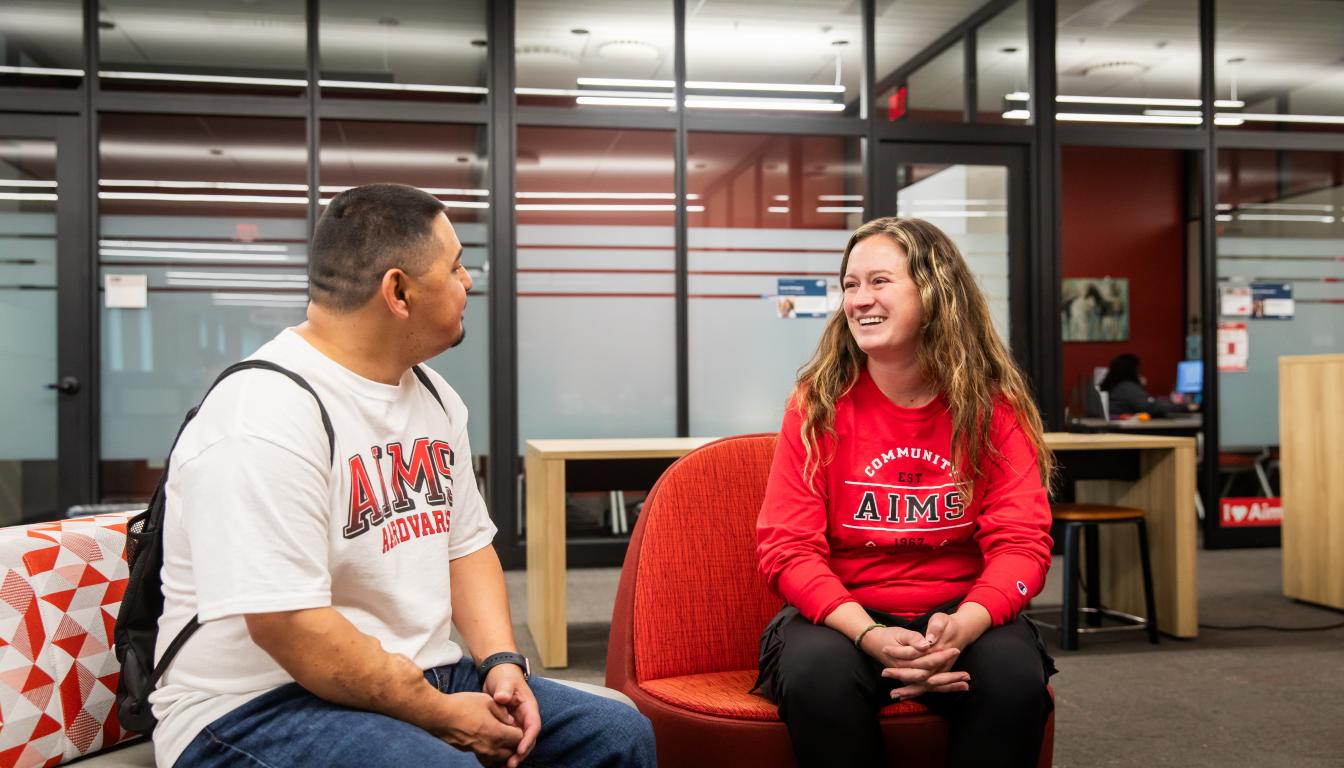 Aims staff member and student sit together in an office